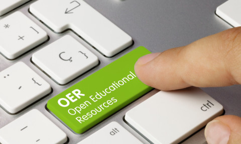 A finger presses a green keyboard key labeled "OER Open Educational Resources," symbolizing access to free educational materials.
