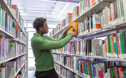 a student removing a book from the stacks