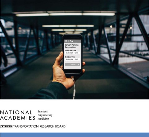 A person holding a smartphone displays an airport parking reservation with entry and exit details in a modern terminal corridor.