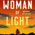 A silhouetted woman stands on a hill under a vibrant red and orange sunset, surrounded by dark blue clouds. Text reads "Woman of Light" and details the author.